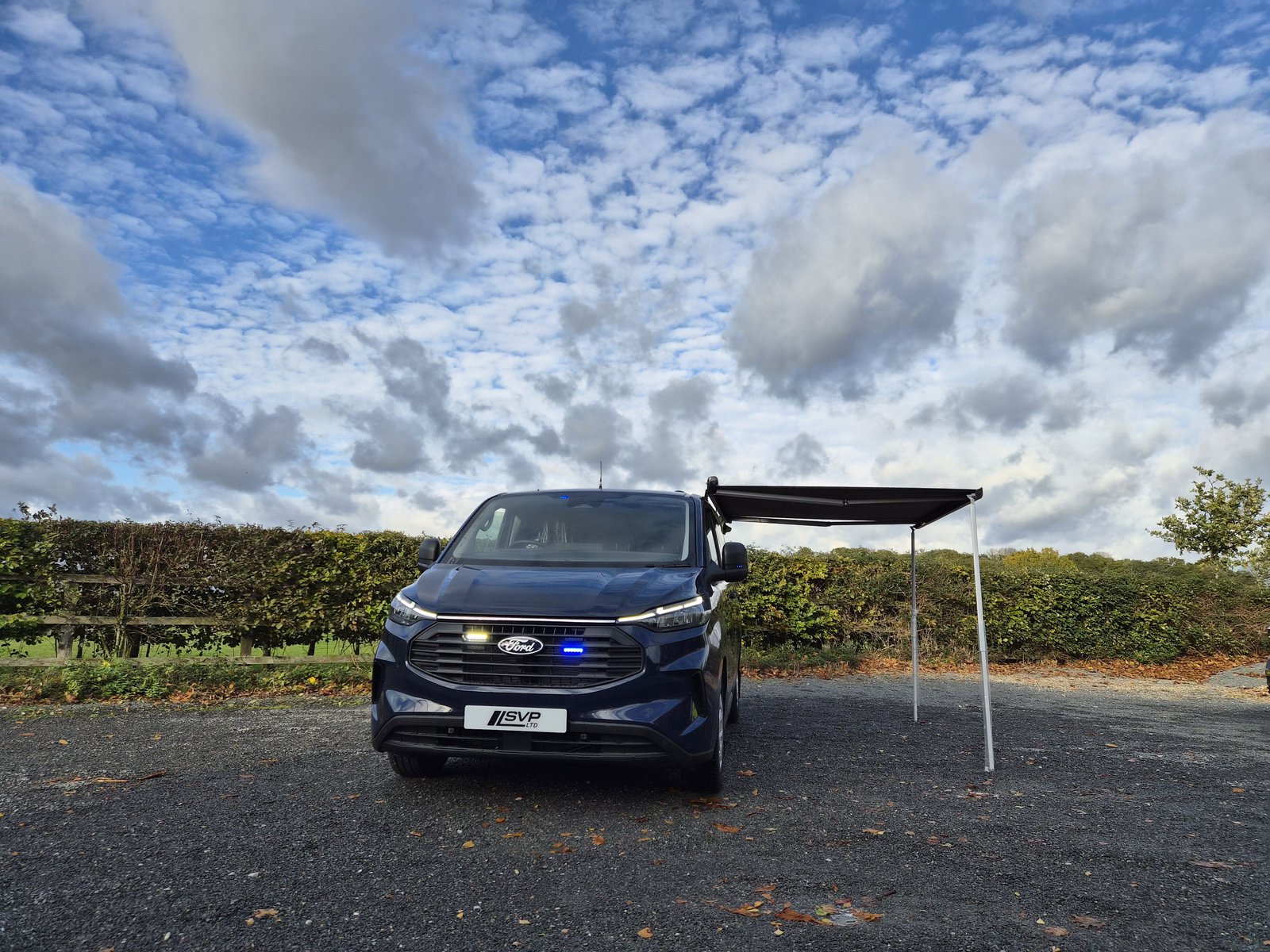 Police Examiner van, front view with awning and blue lights