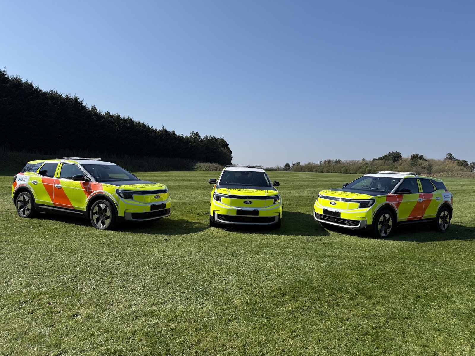 National Highways Inspector vehicles, three parked on grass
